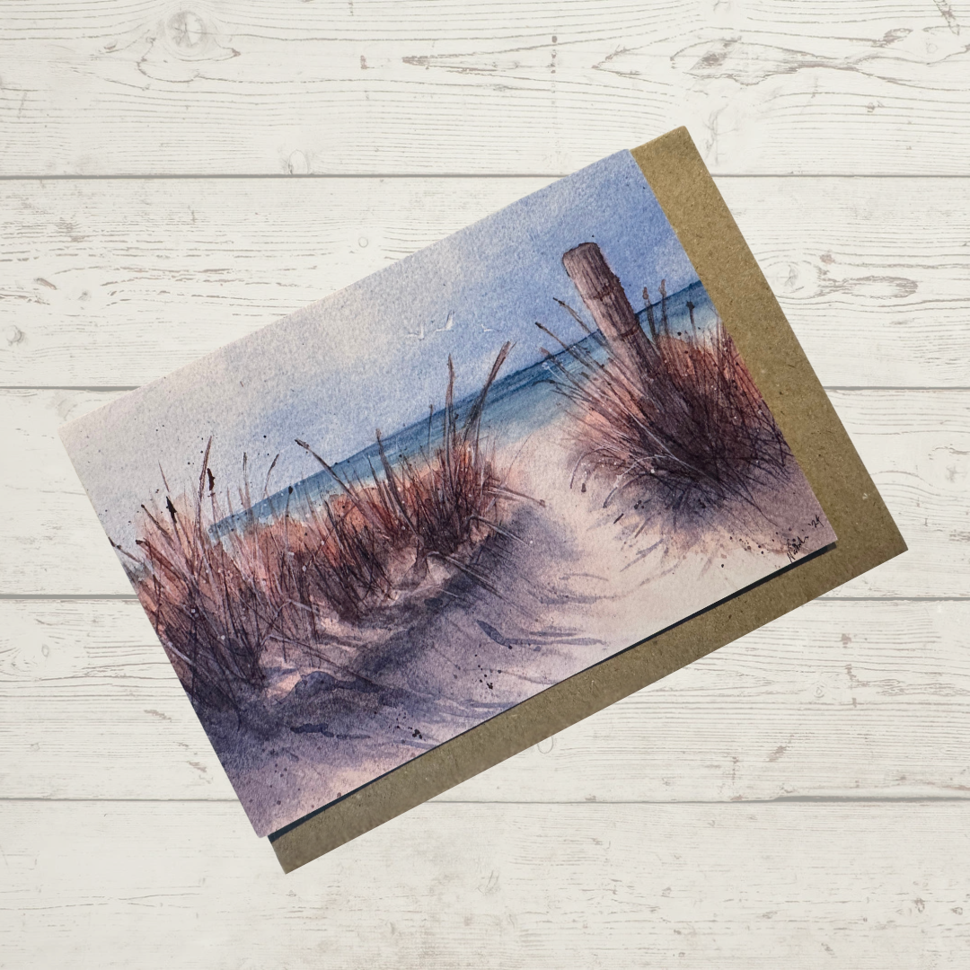 Image of actual card with natural coloured kraft paper envelope. Image depicts a sandy path through beach grass and old fence post to the beach.